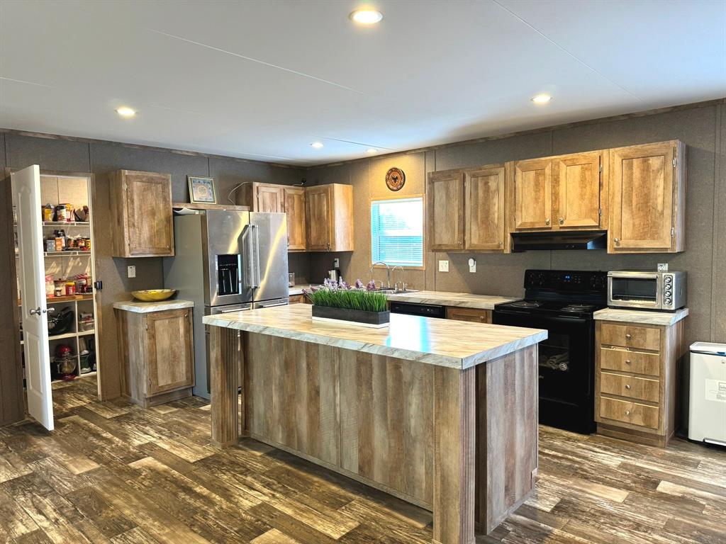 a kitchen with a refrigerator a stove top oven and a window