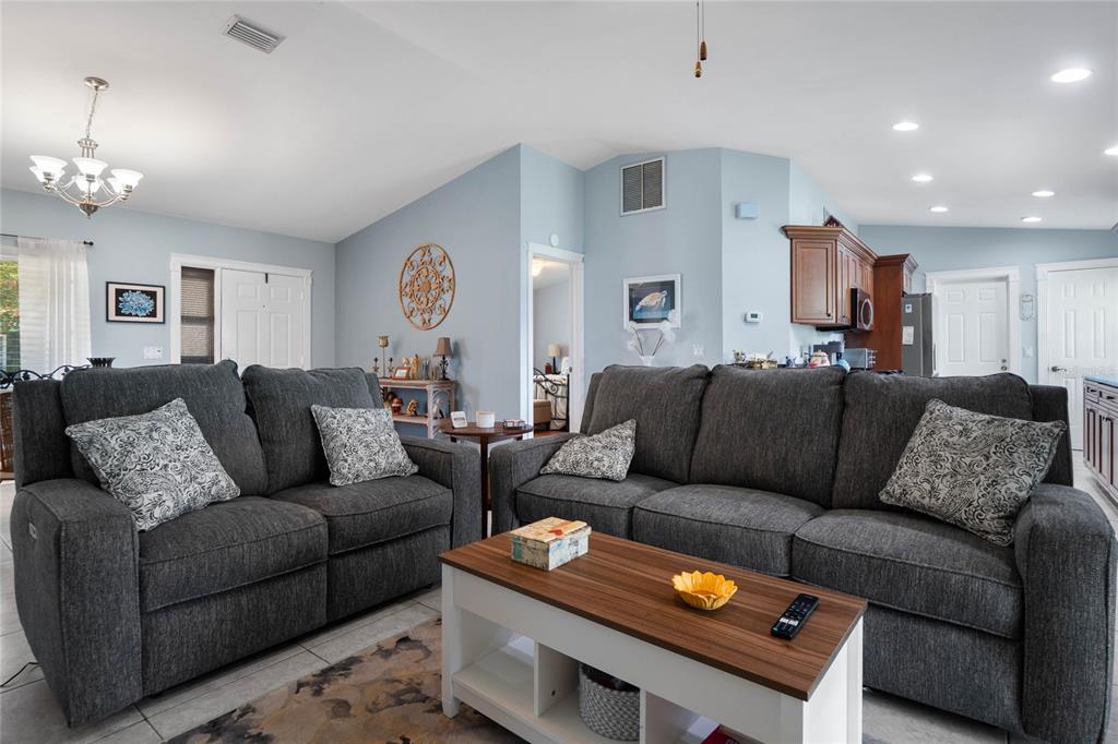 a living room with furniture and a dining table with wooden floor