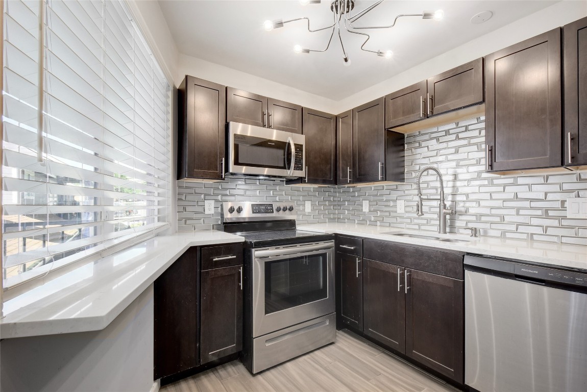 a kitchen with a sink stainless steel appliances and cabinets