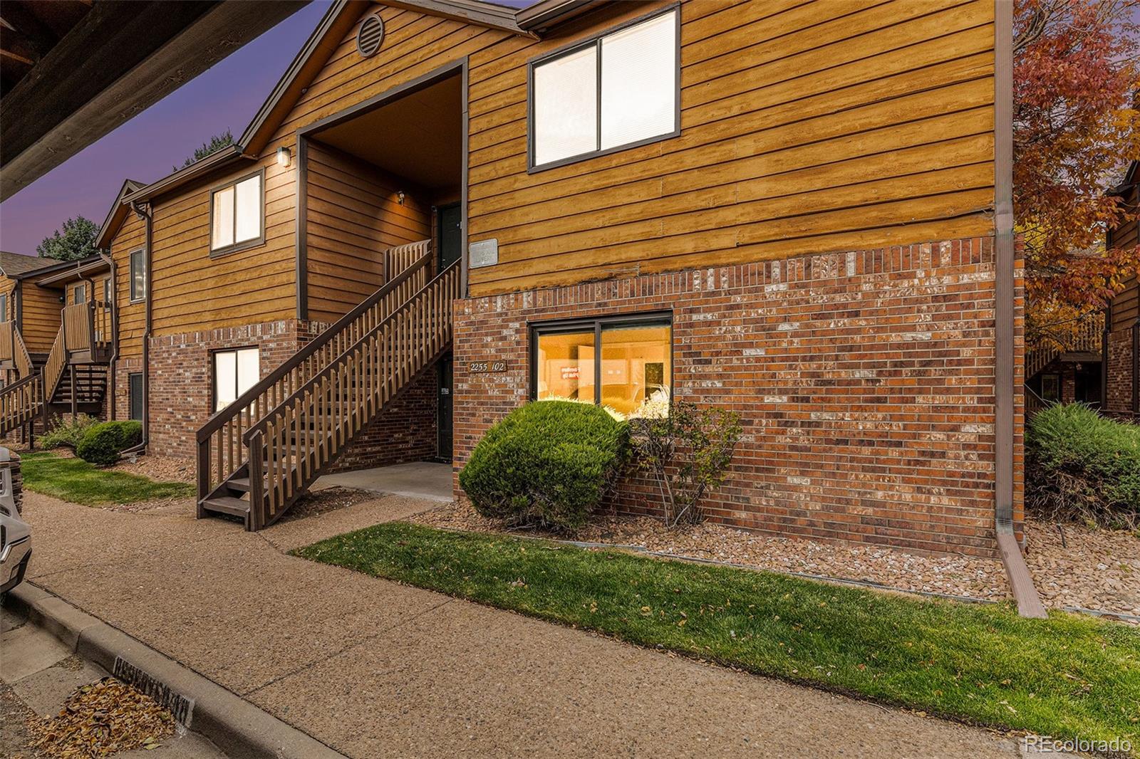 a view of a house with brick walls and a small yard