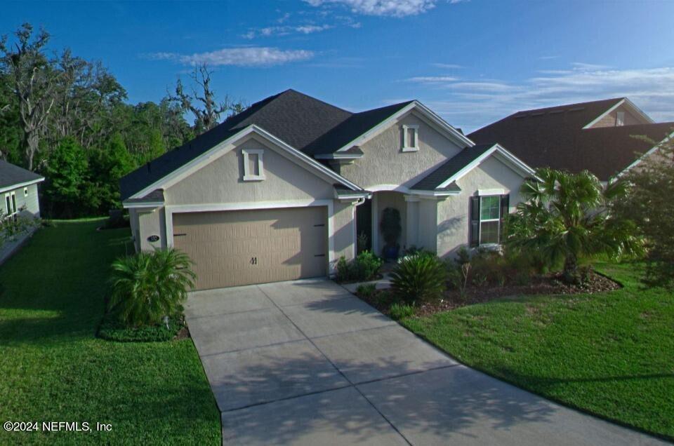 a front view of a house with a yard and garage