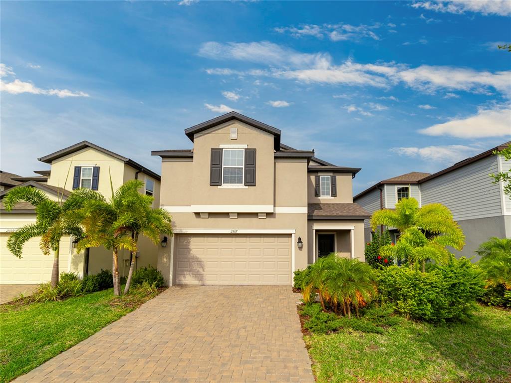 a front view of a house with a yard and garage