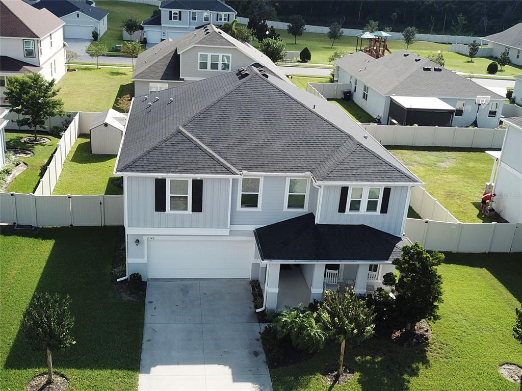 an aerial view of a house with a yard