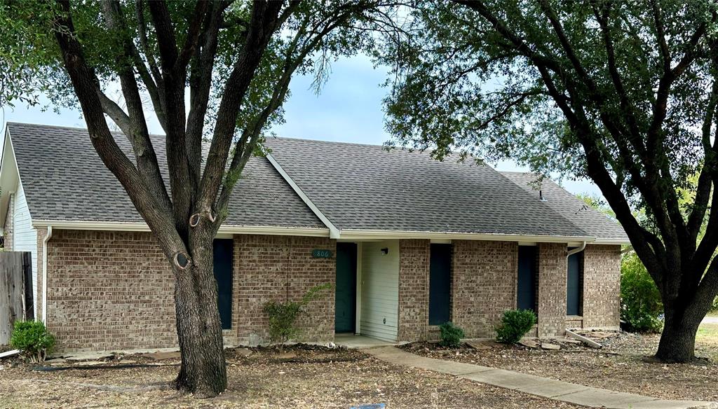 a front view of a house with yard and trees