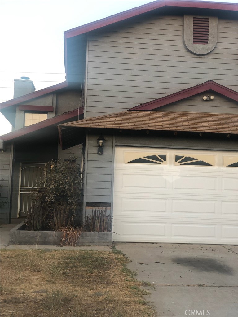 a view of a house with a car parked on road