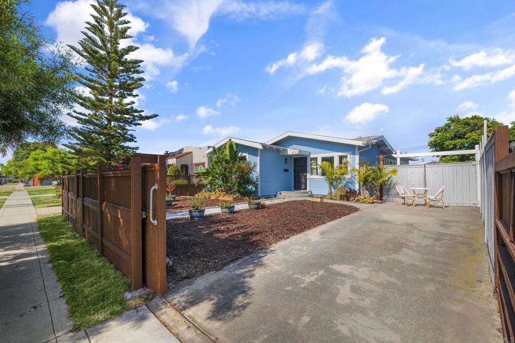 a view of a house with wooden fence next to a road