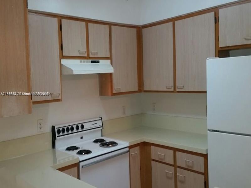 a kitchen with stainless steel appliances a refrigerator and a stove top oven