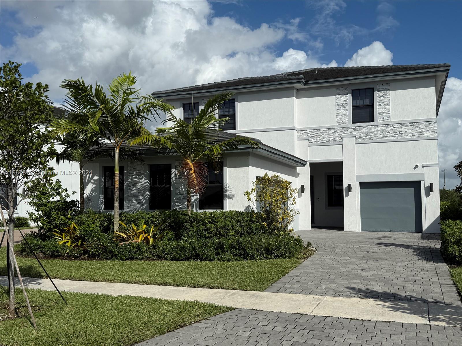 a front view of a house with a yard and garage