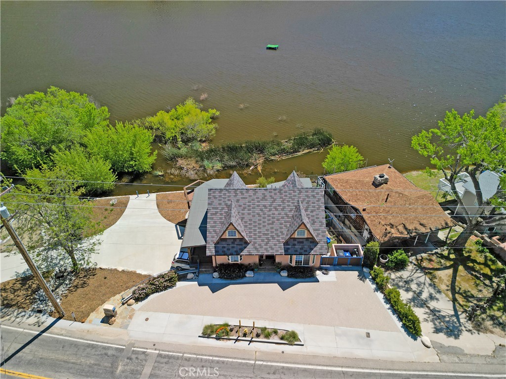 an aerial view of a house with a yard and seating space