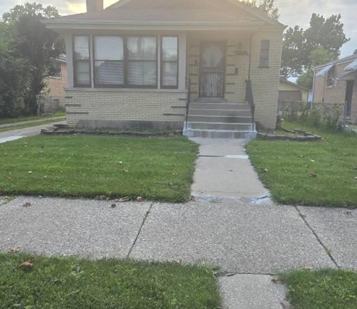 a front view of a house with a garden and plants