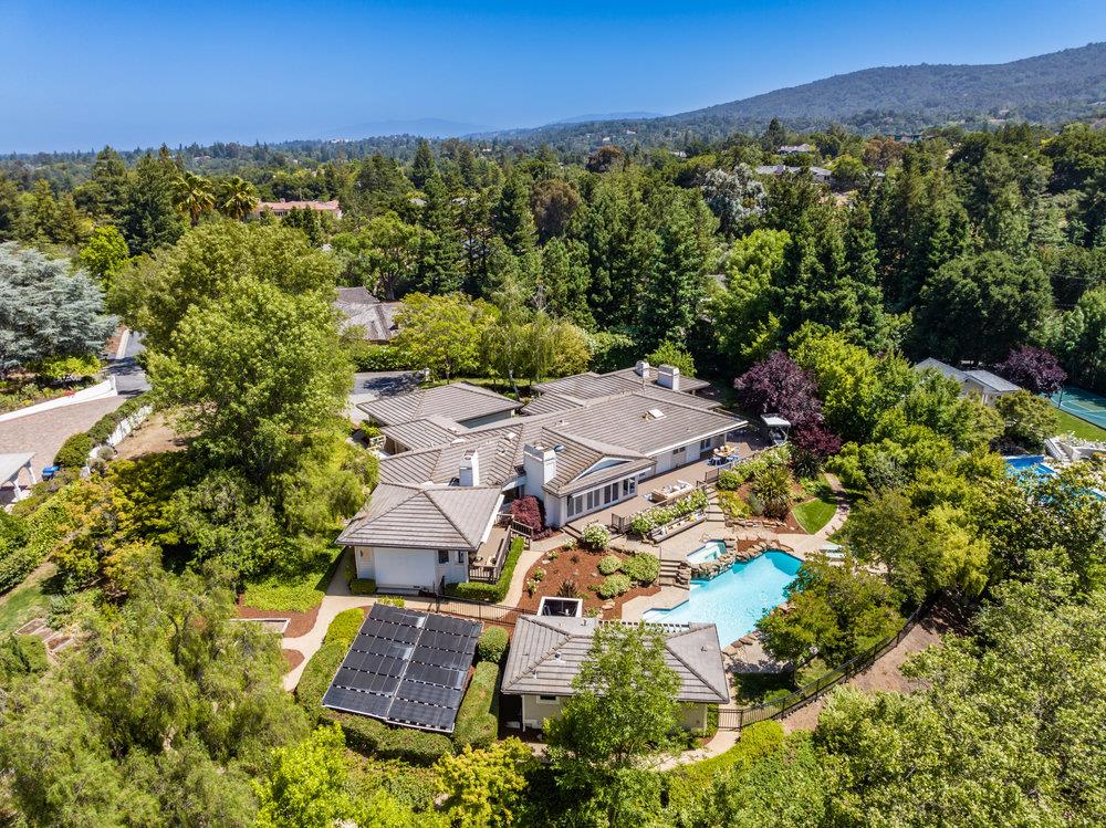 an aerial view of residential houses with outdoor space and trees