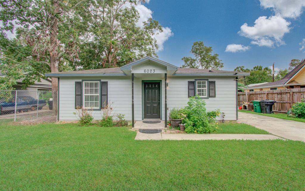 a front view of a house with a garden and yard