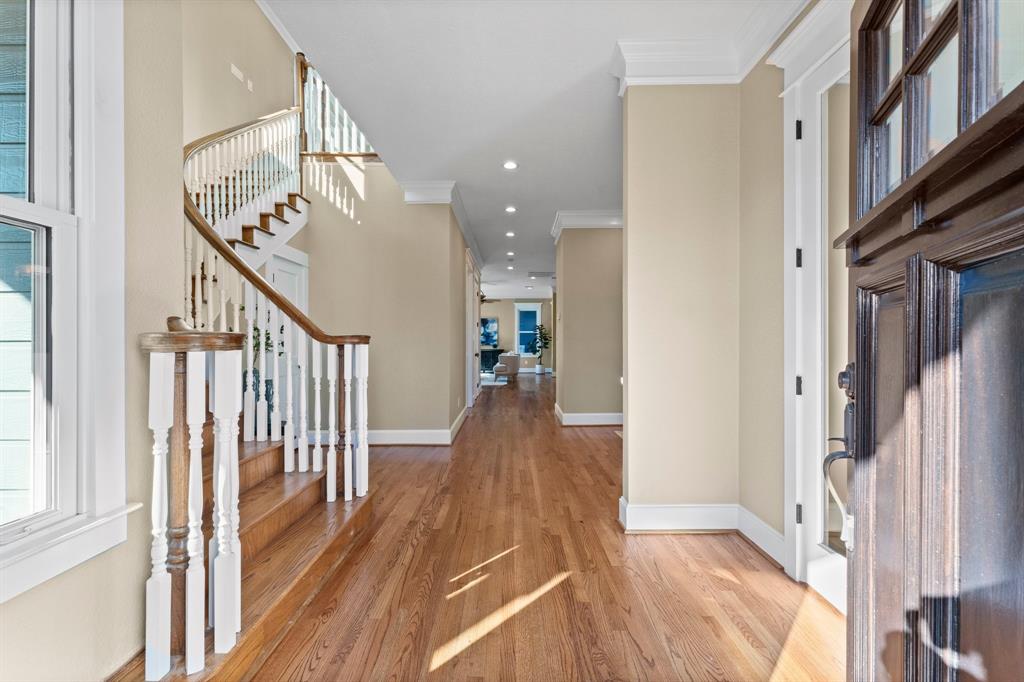 a view of a hallway with wooden floor and staircase