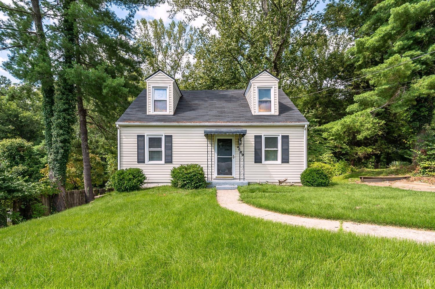 a front view of a house with a yard and trees