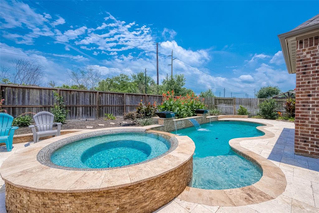 Welcome home.  Your gunite pool awaits and is accented with travertine tile and classy water features.