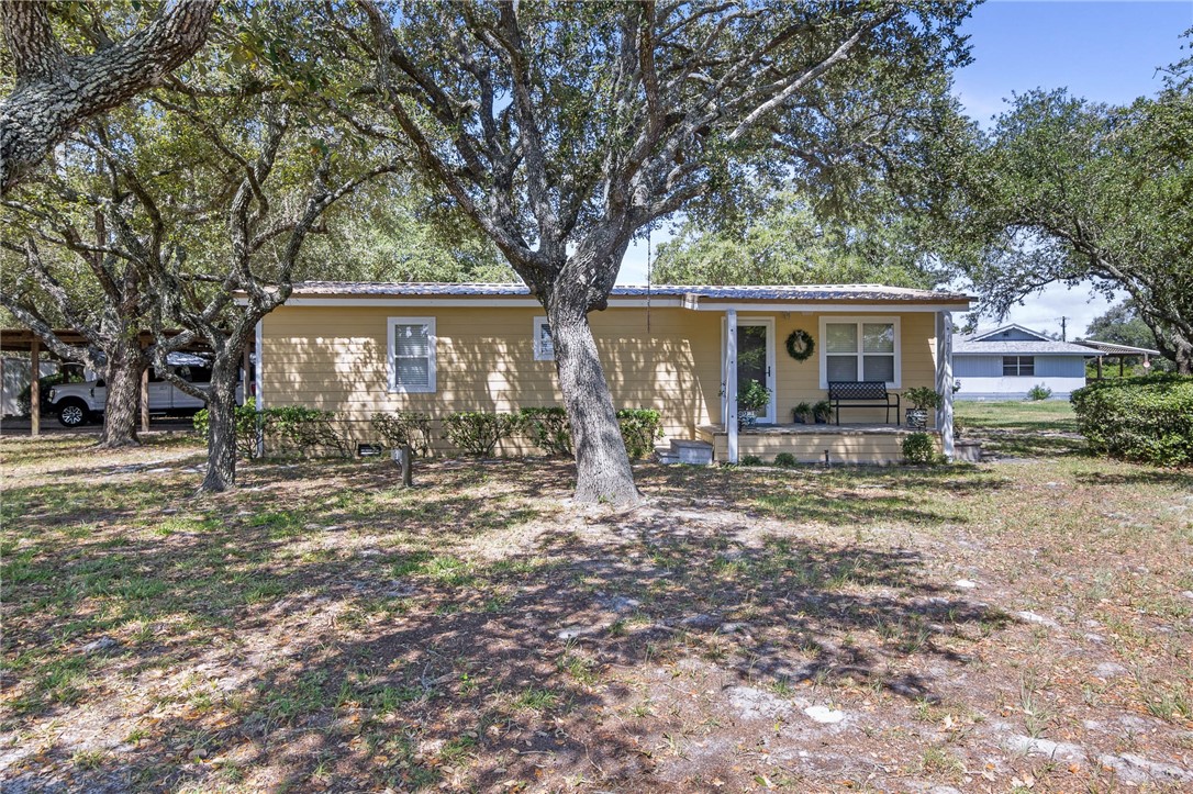 a view of a house with yard and a tree