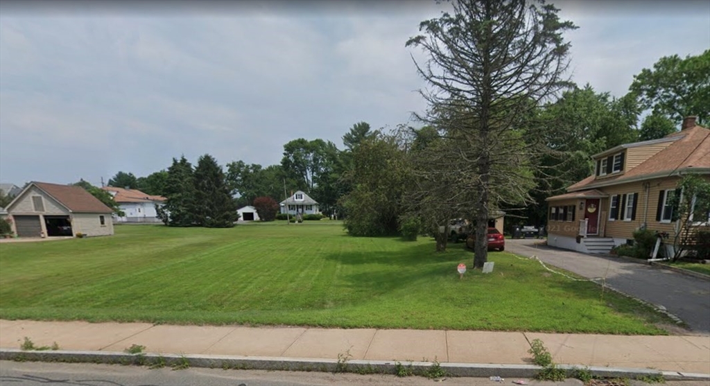 a front view of a house with a yard and trees