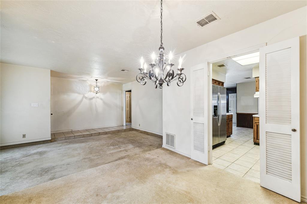 a view of a chandelier in big room and a bathroom