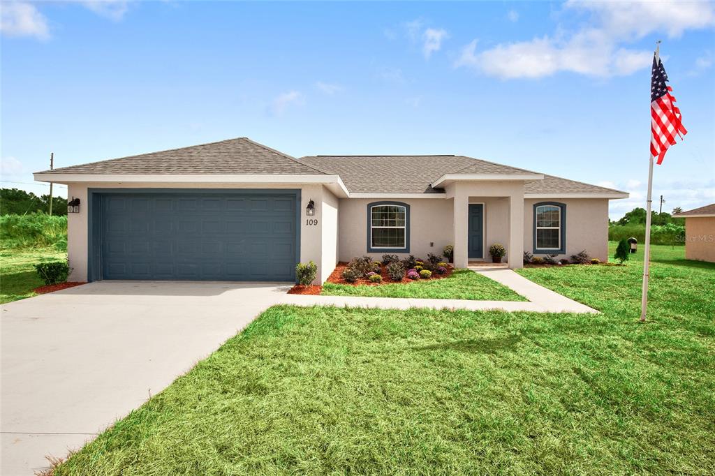 a front view of a house with a yard and garage