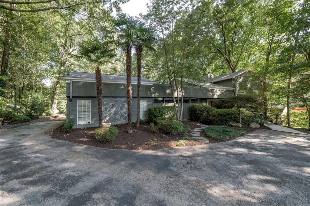 a view of a house with a yard and large tree