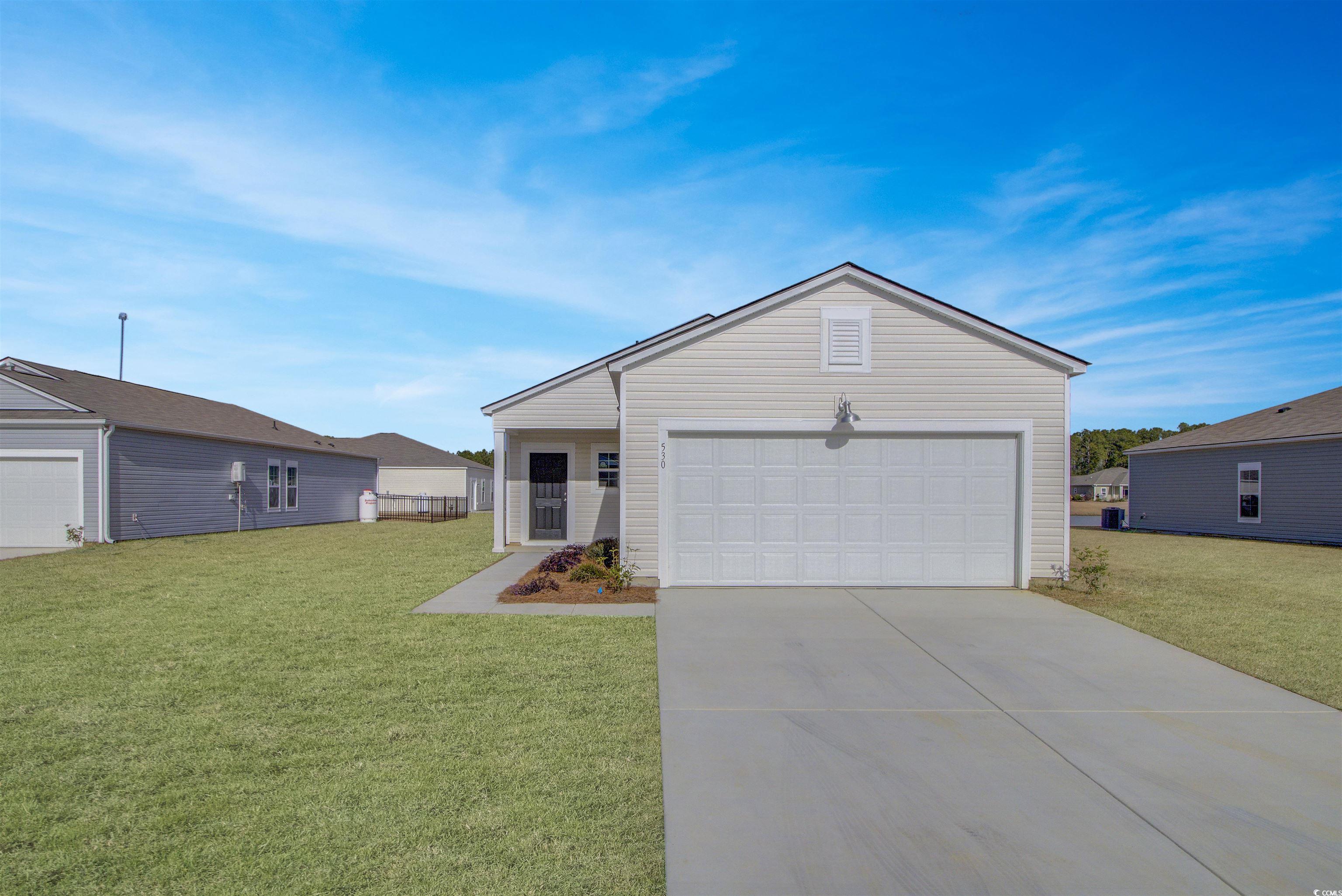 Single story home featuring a garage and a front y