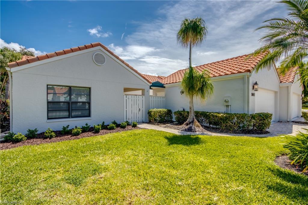 Mediterranean / spanish-style home featuring a front yard and a garage