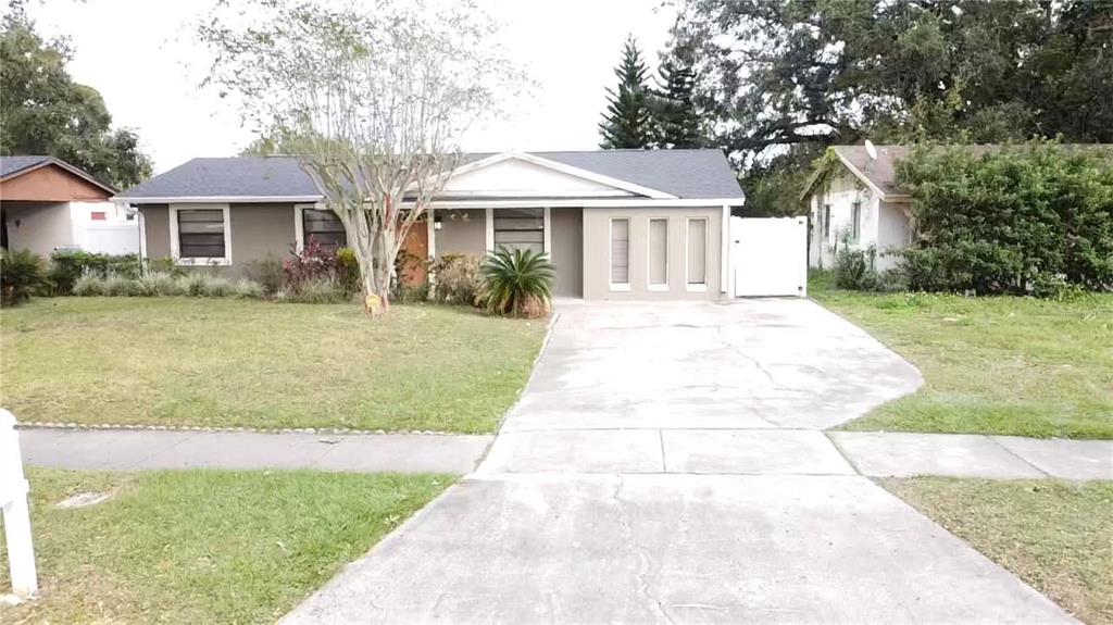 a front view of a house with a garden and trees