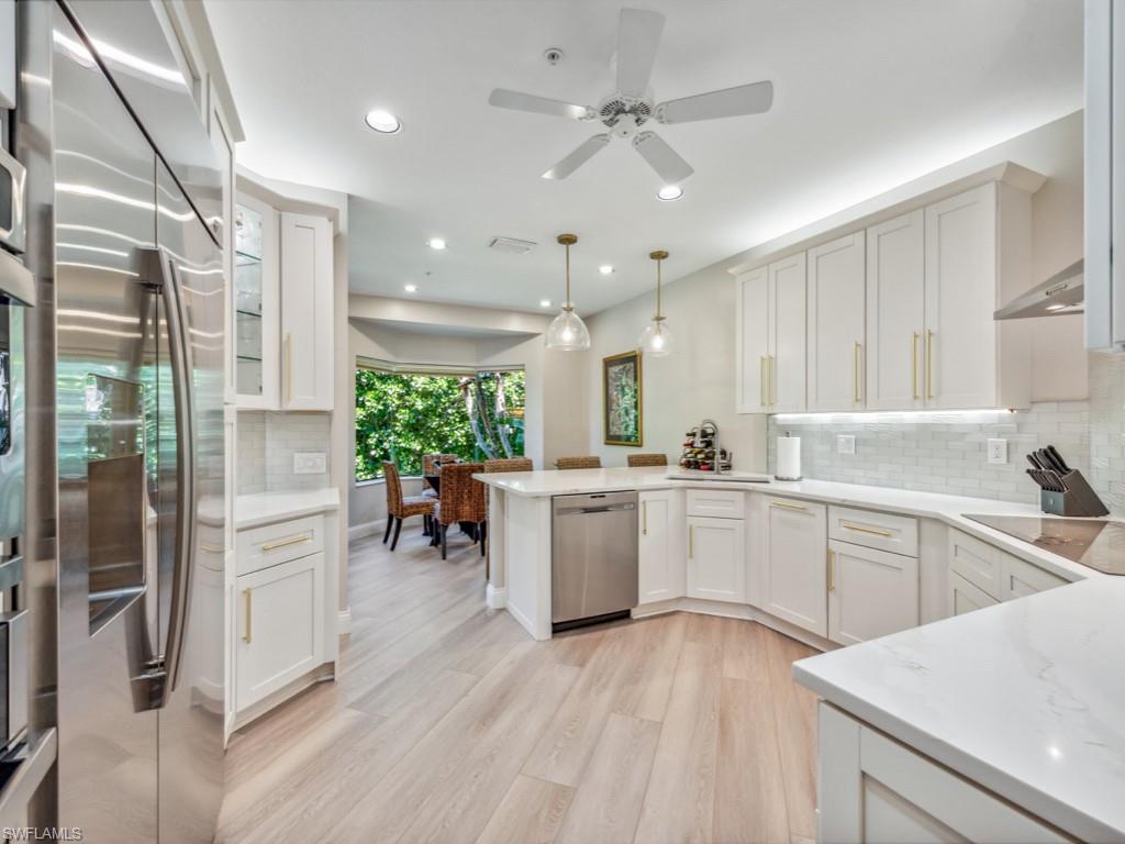 a kitchen with a refrigerator and white cabinets