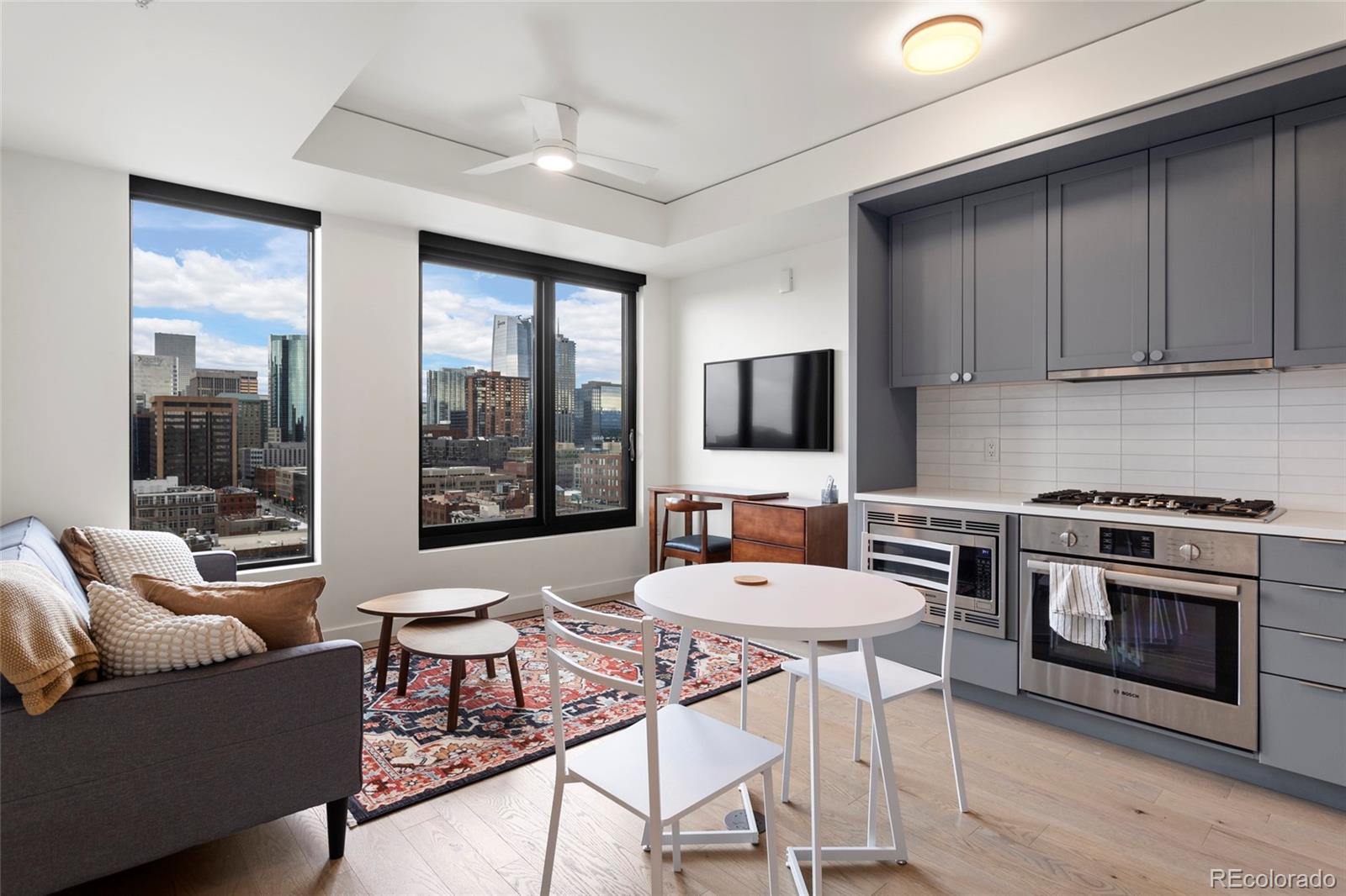 a living room with furniture a flat screen tv and a floor to ceiling window