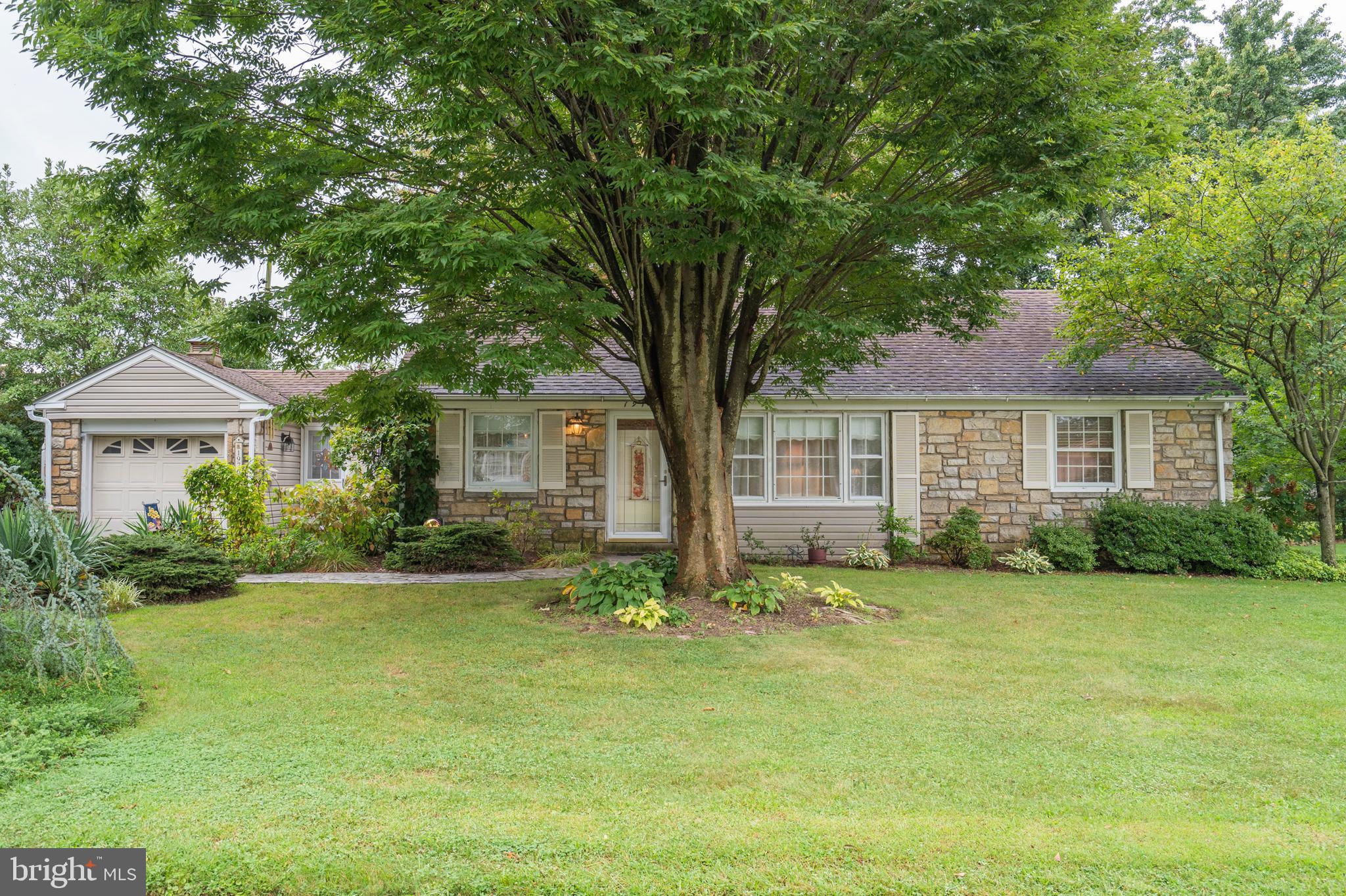 a front view of a house with a garden and yard