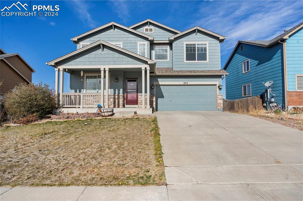 Craftsman-style house featuring a garage, a porch, and a front yard