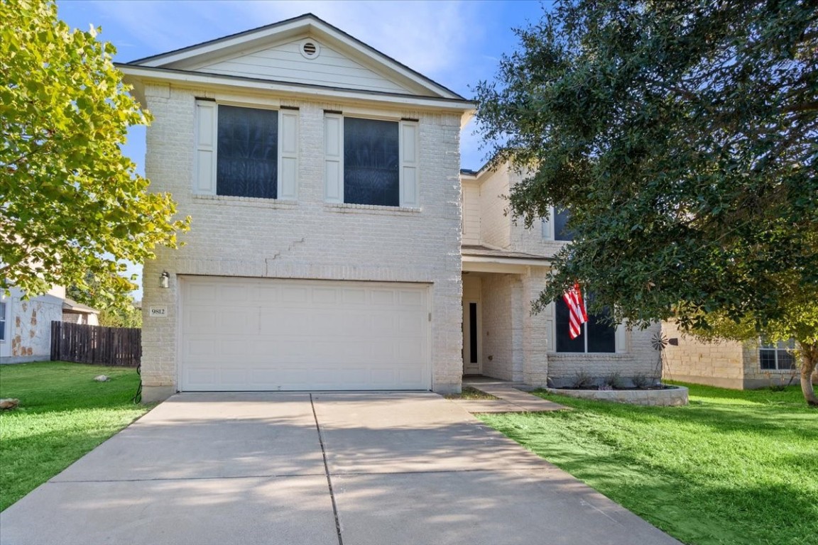 a front view of a house with a yard and garage