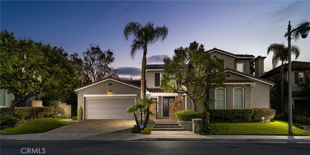 a front view of a house with a garden and trees