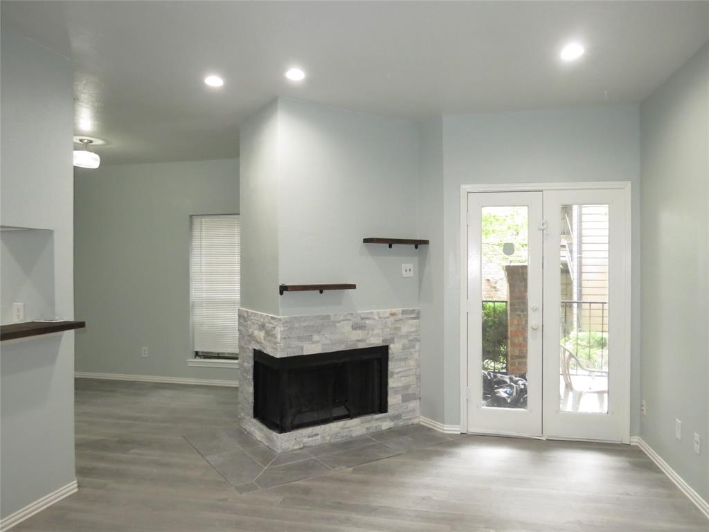 a view of an empty room with a fireplace and a window