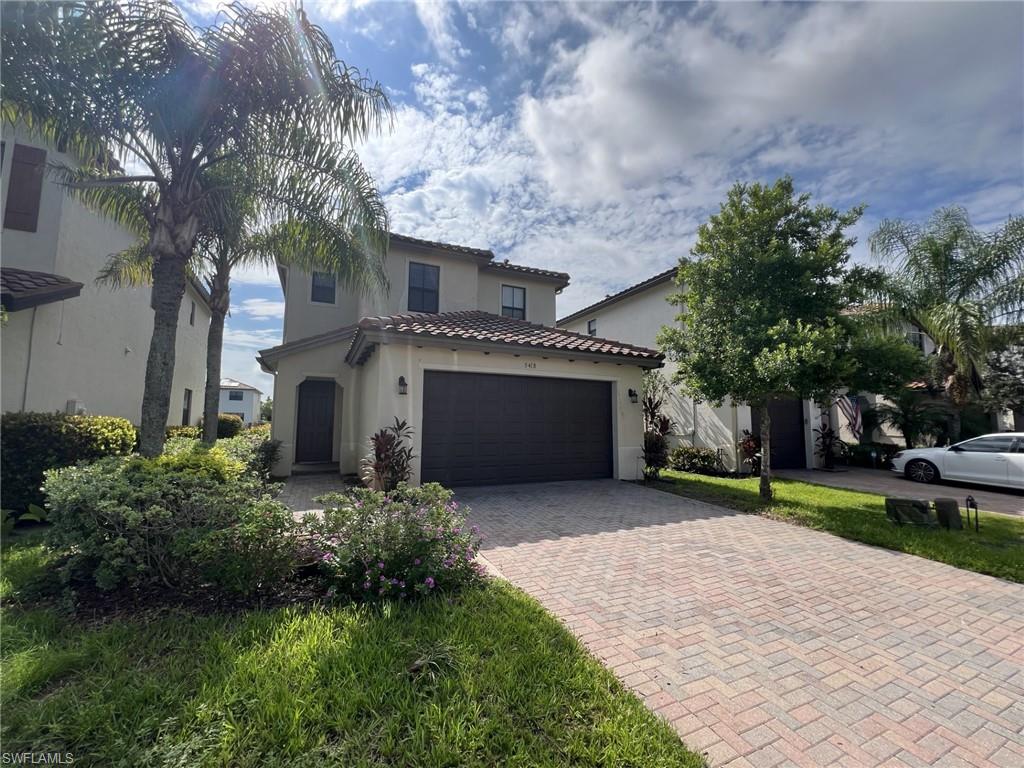 a front view of a house with a yard and garage