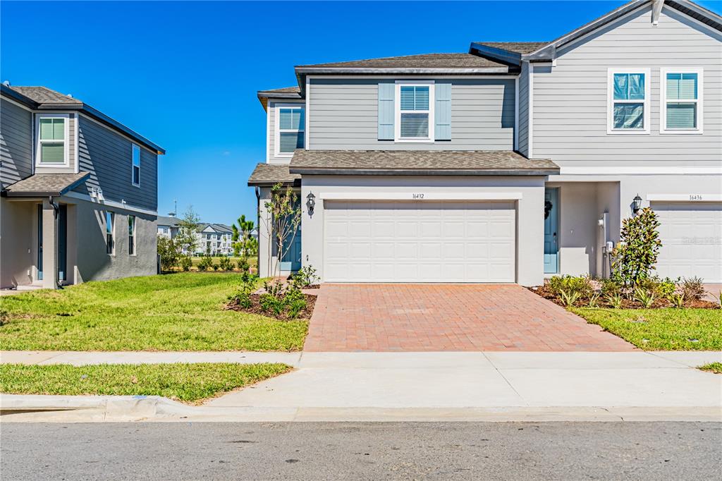 a front view of a house with a yard and garage