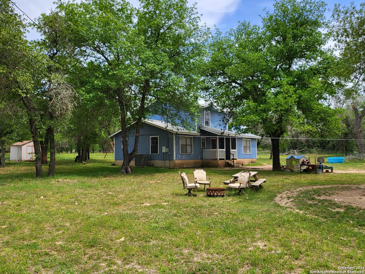 a backyard of a house with table and chairs