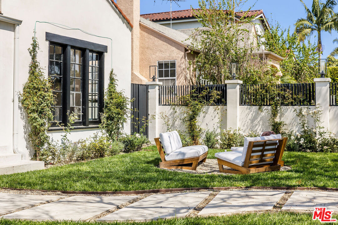 a view of a house with backyard sitting area and garden