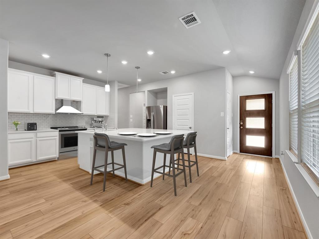 a open kitchen with kitchen island wooden floors and center island