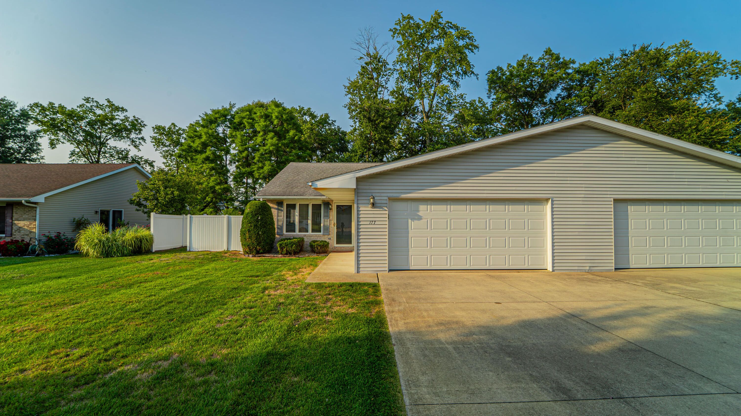 a front view of house with yard and trees in the background