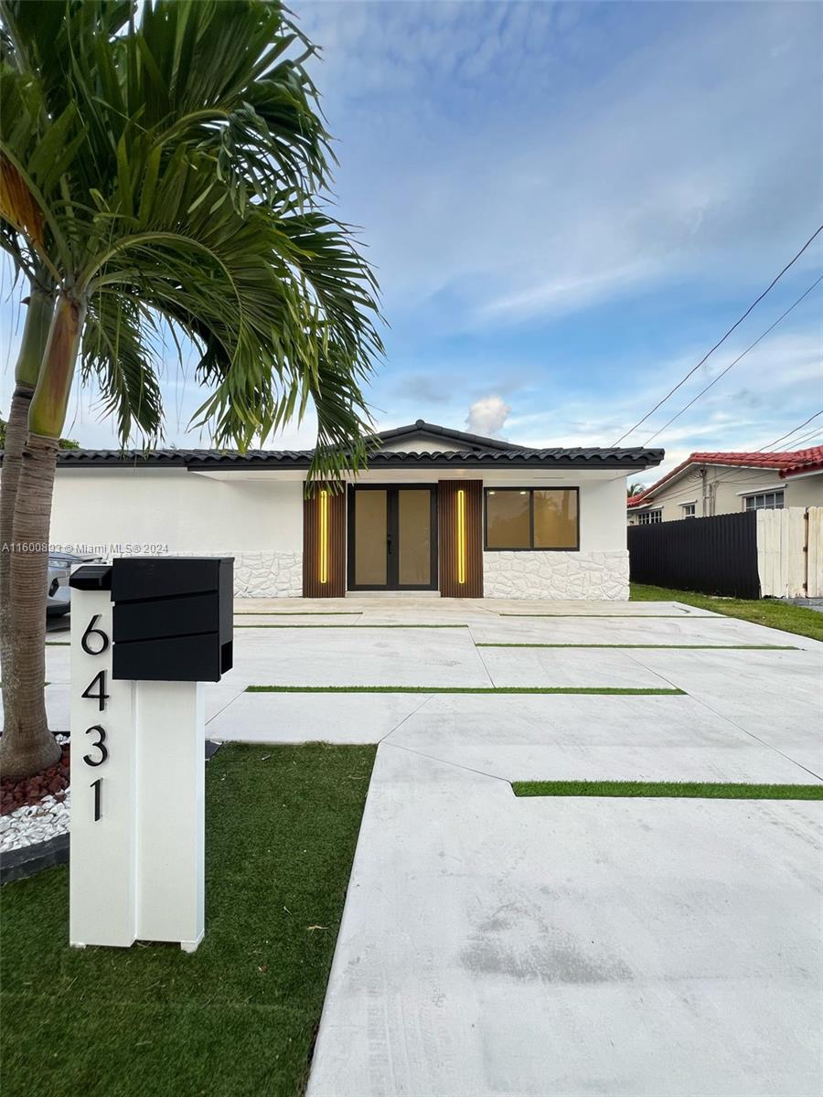 a front view of a house with a garden and parking space