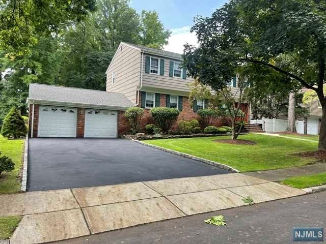 a front view of a house with a yard and a garage