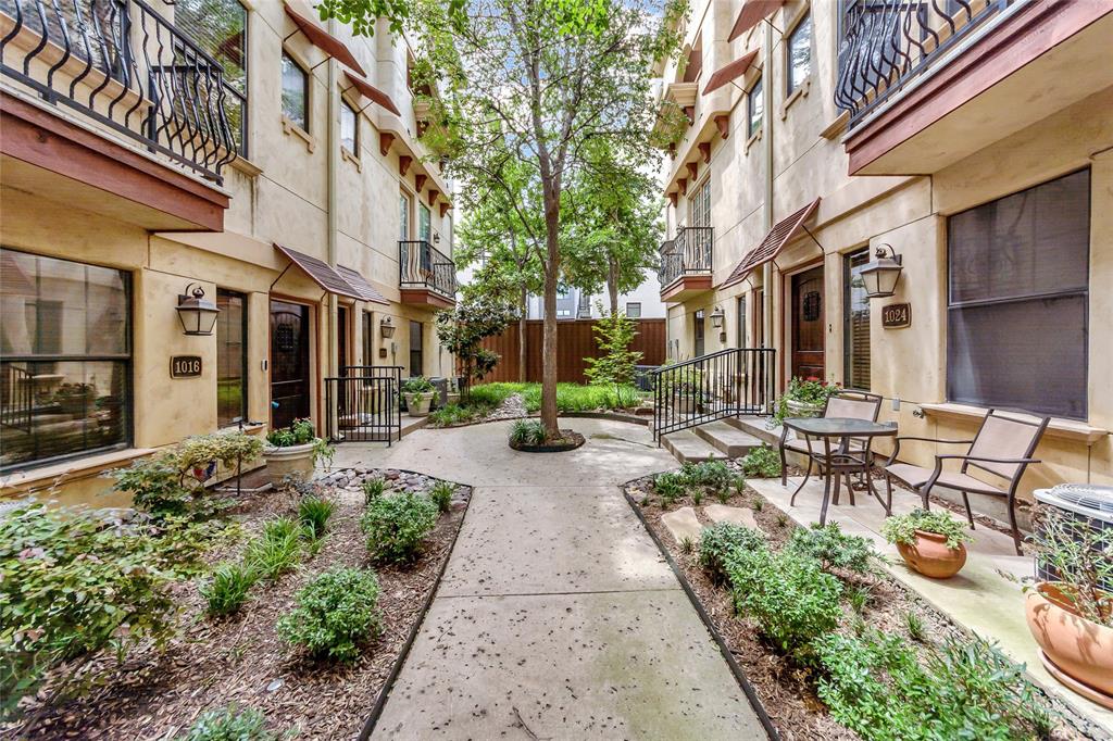 a view of a patio with table and chairs next to a building