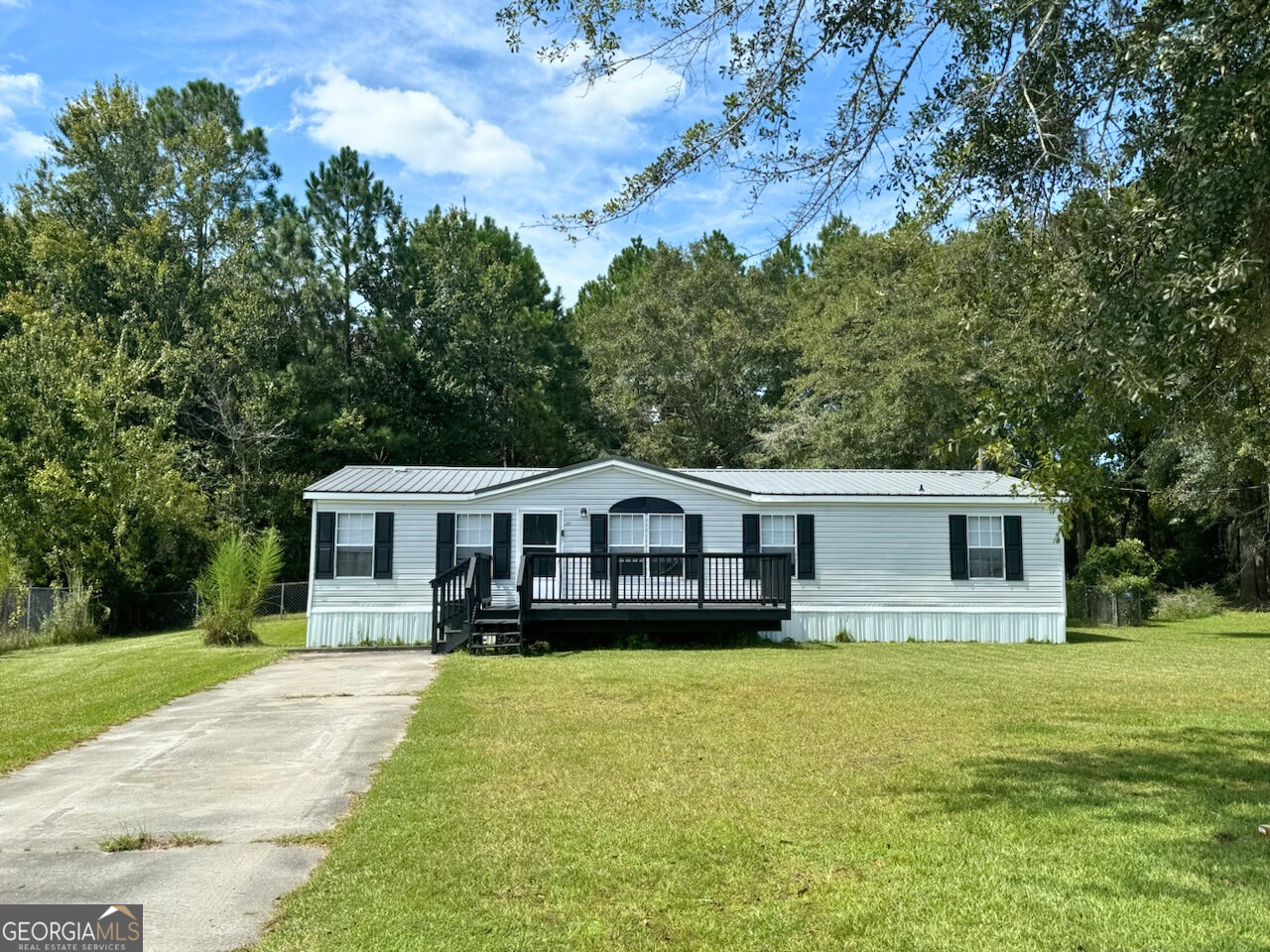 a front view of a house with a garden and trees