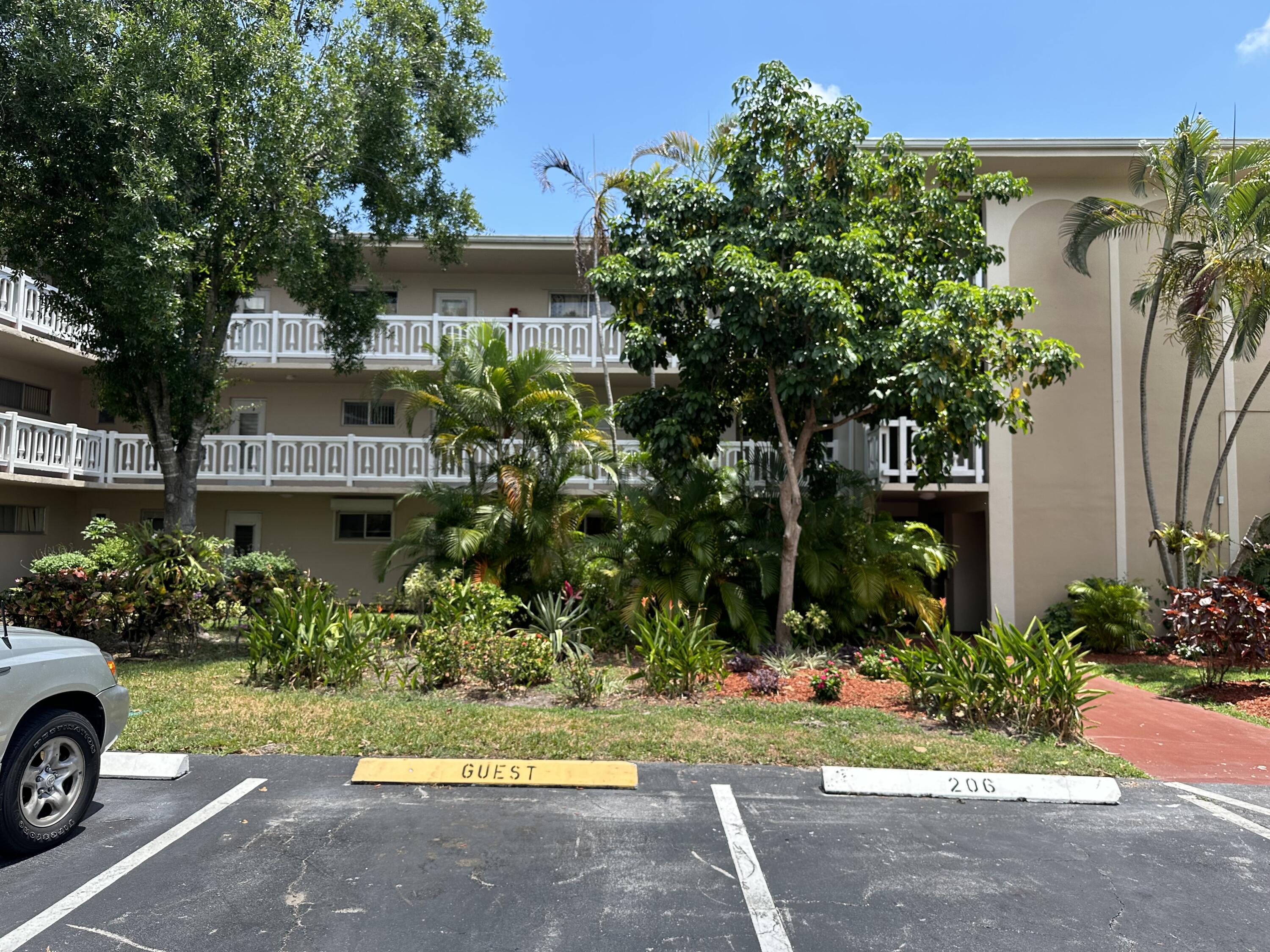 a view of a house with garden and a car park