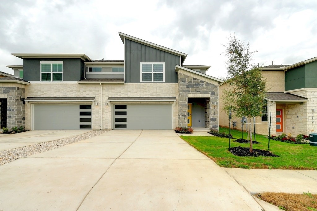 a front view of a house with yard and parking