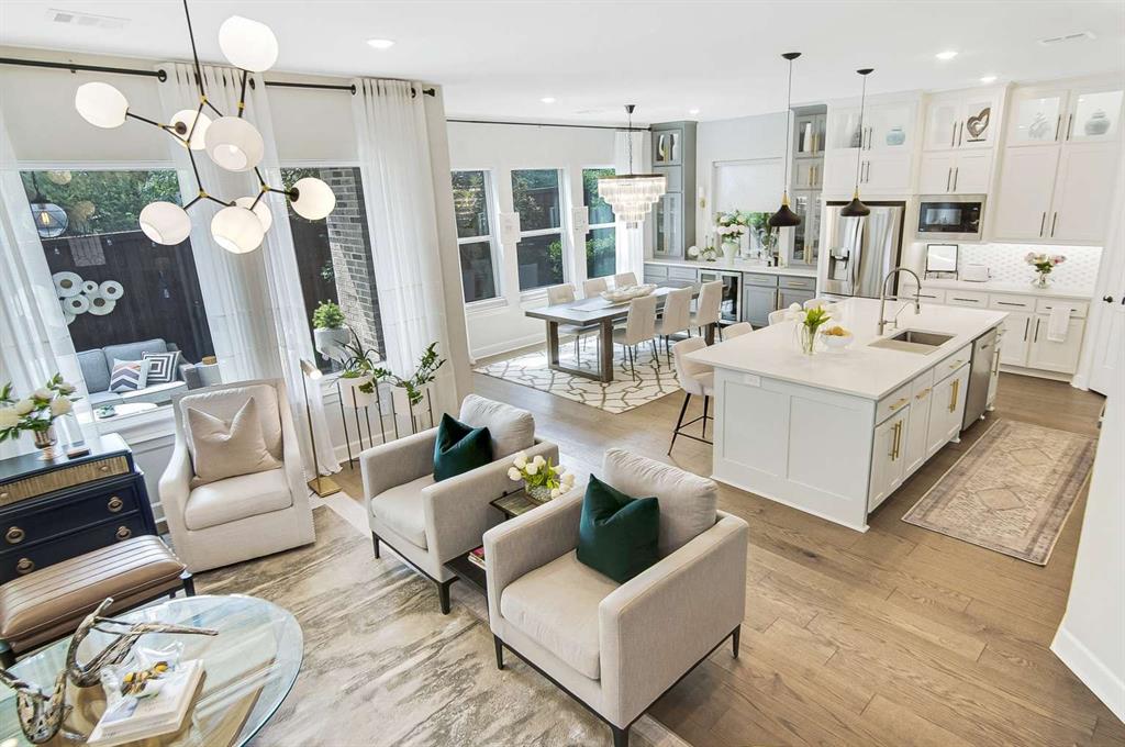 a living room with furniture kitchen view and a chandelier