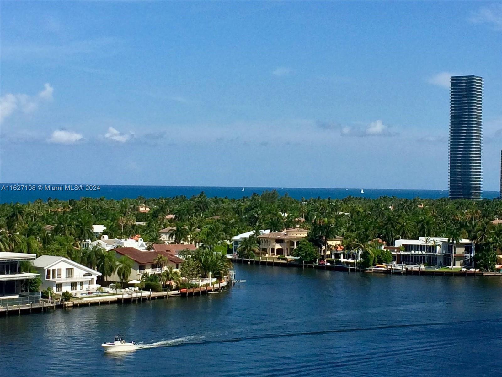 a view of a ocean with boats and trees in the background