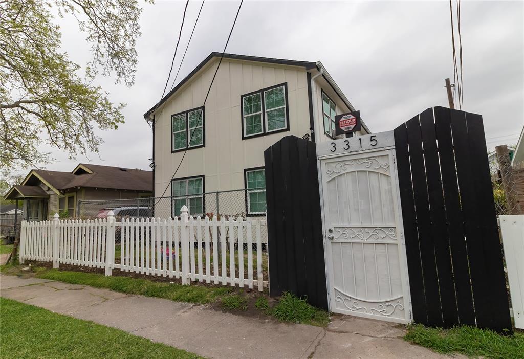 a view of a house with a wooden fence