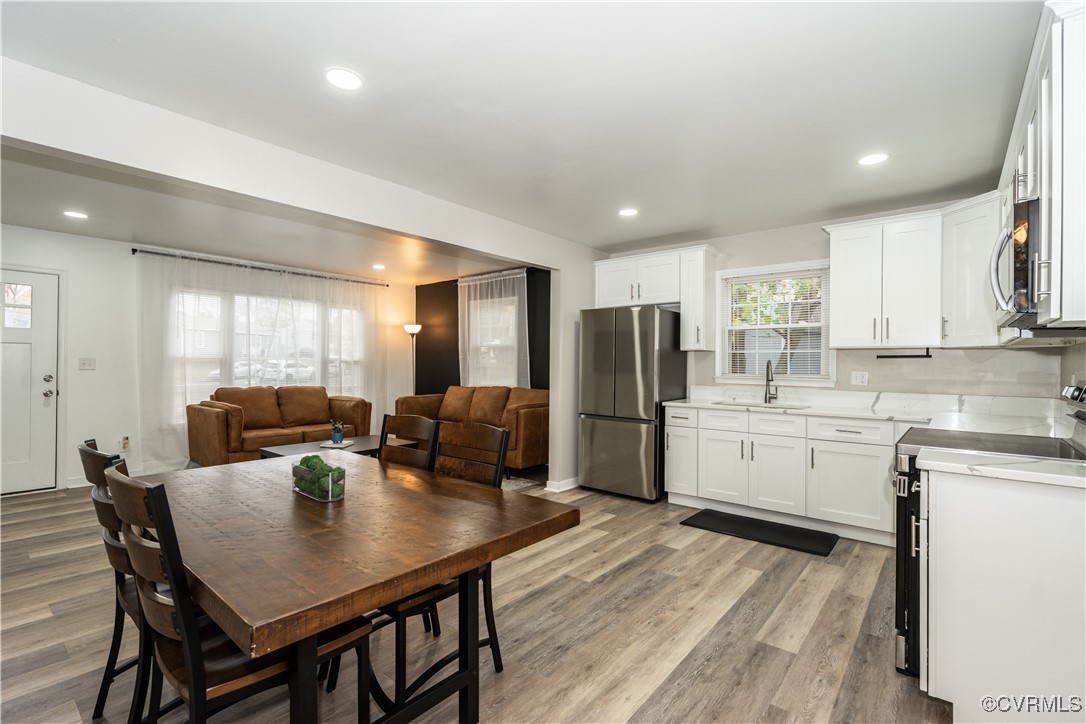 a kitchen with refrigerator and wooden floor